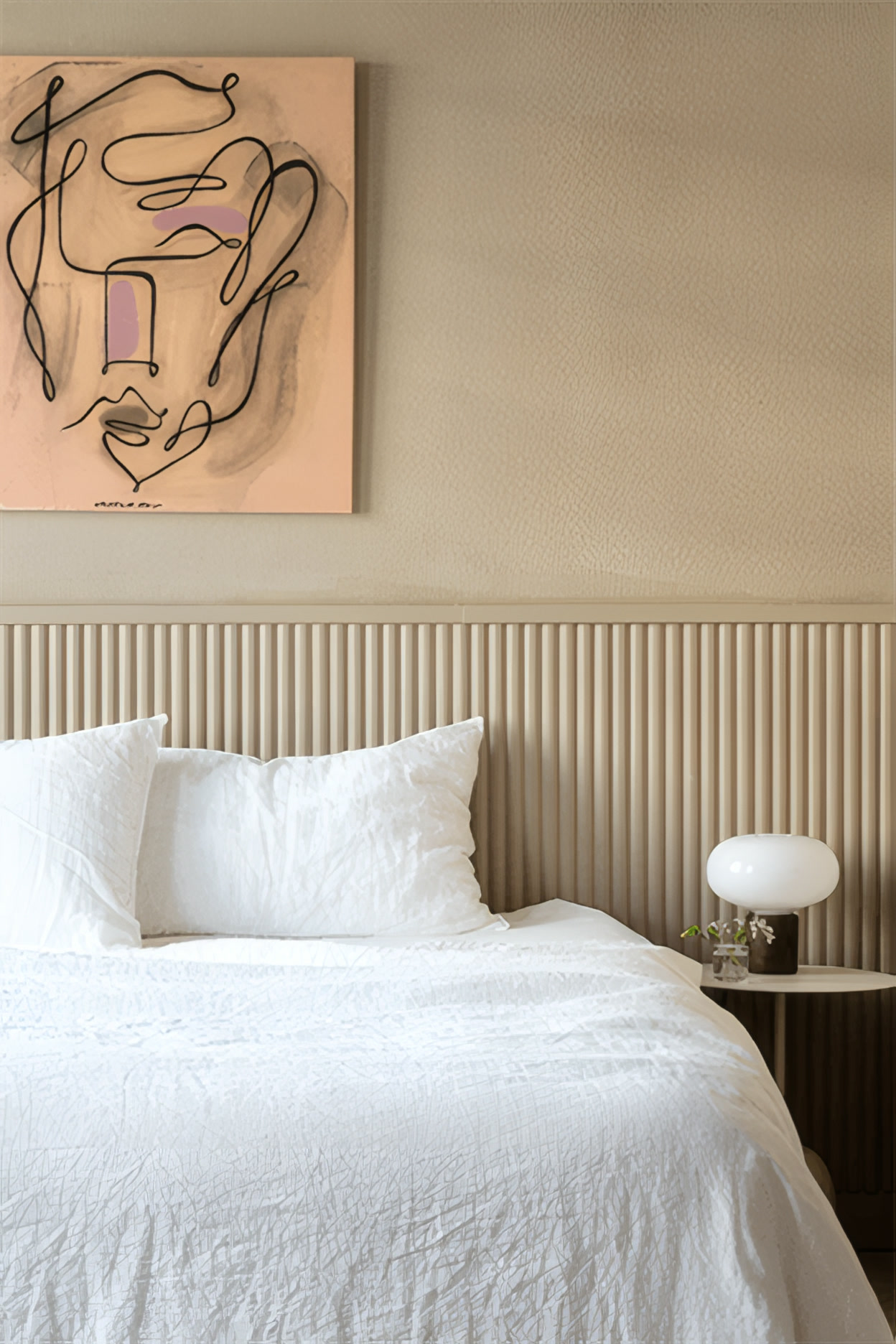 Panneau mural cannelé en tête de lit, dans une chambre aux tons sable (photo Orac Decor)