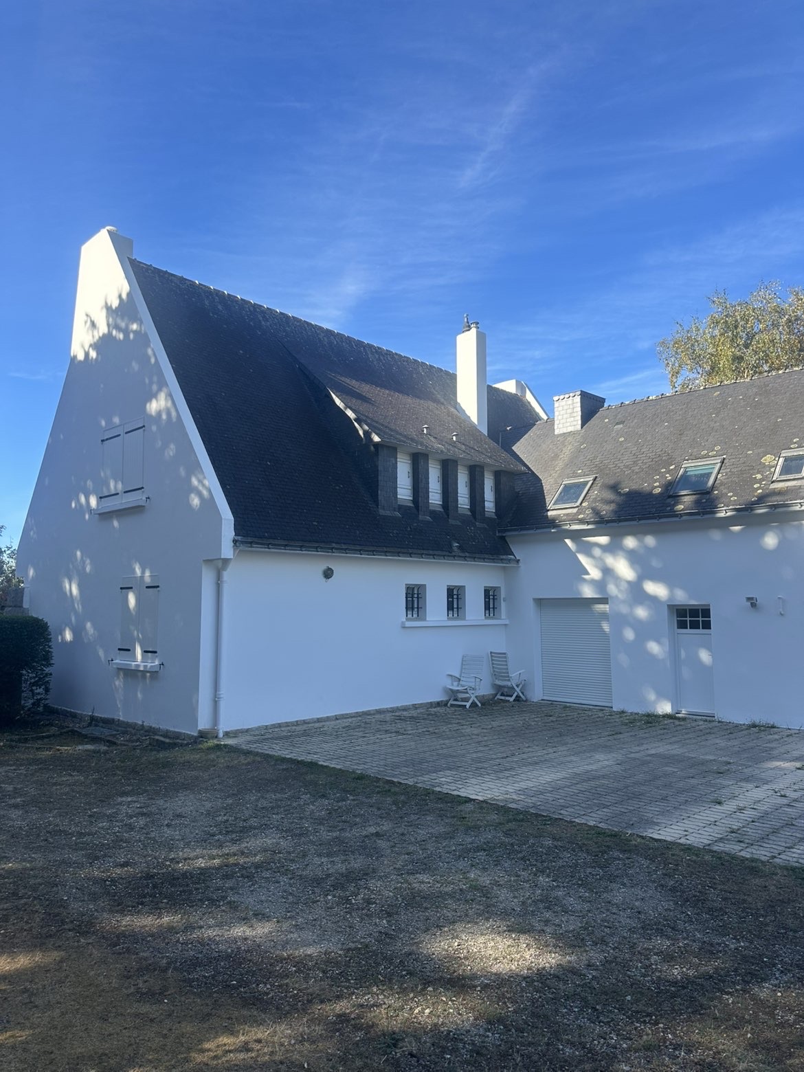 Maison néo-bretonne aux façades blanches, lucarnes et toiture en ardoise