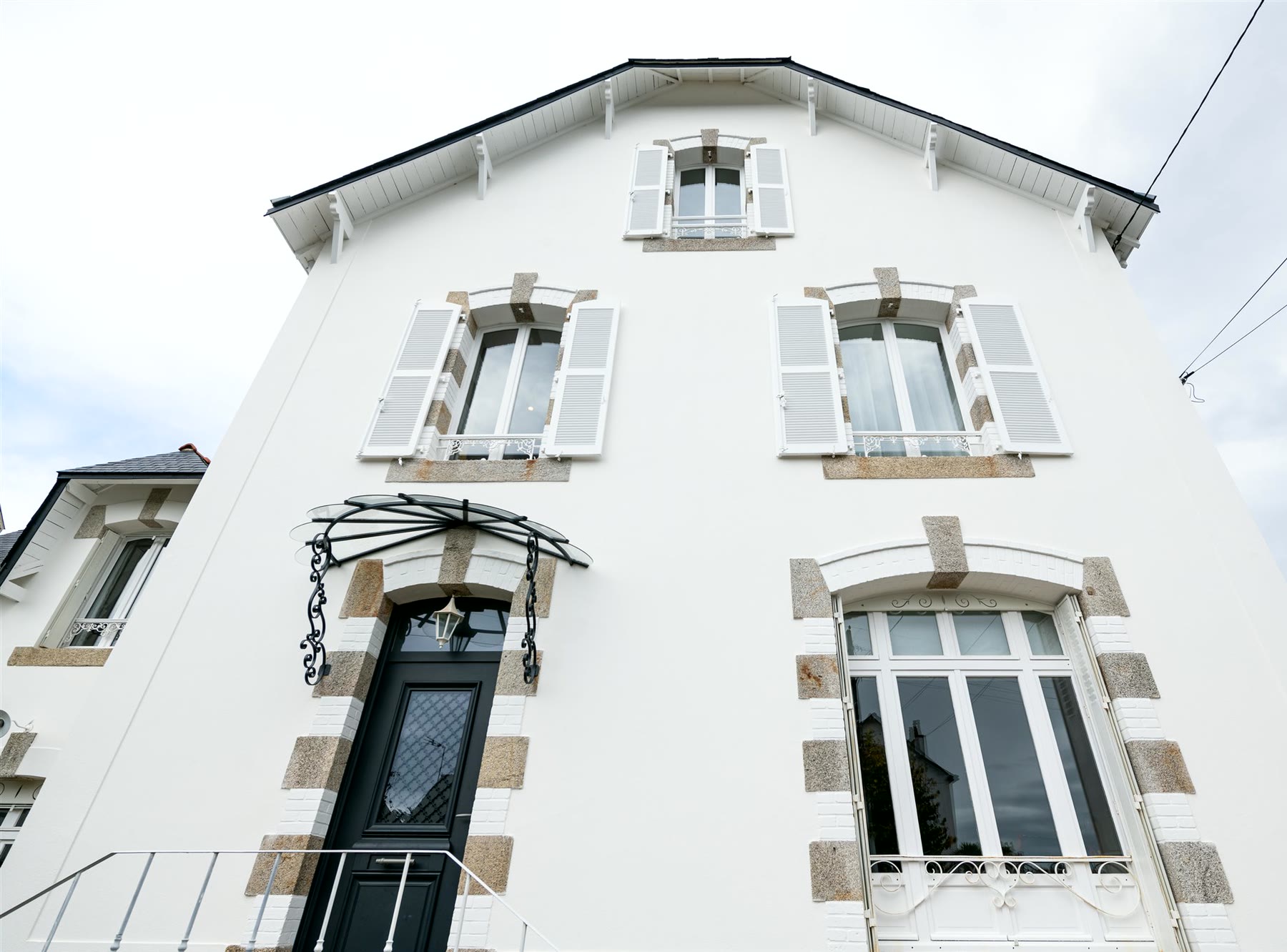 Façade blanche d’une maison de Vannes après ravalement, encadrements de fenêtres en pierre